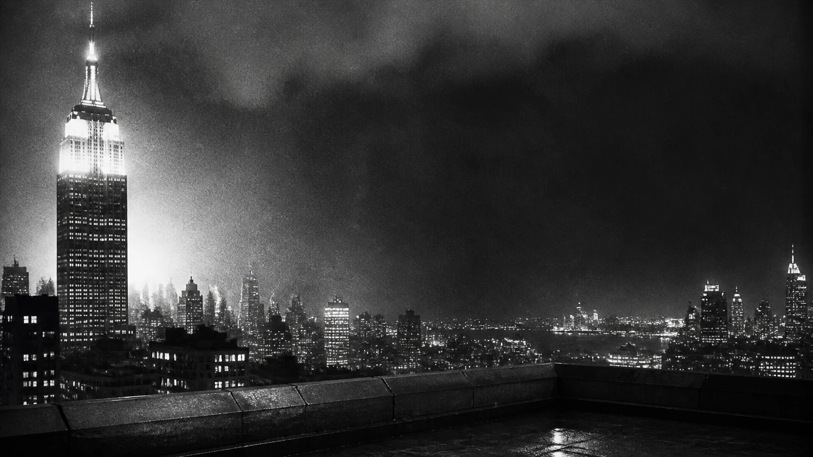 Grainy nighttime view of the Empire State Building from a Manhattan rooftop